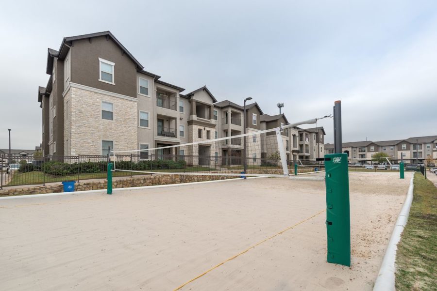 outdoor volleyball court at forum at denton station apartments
