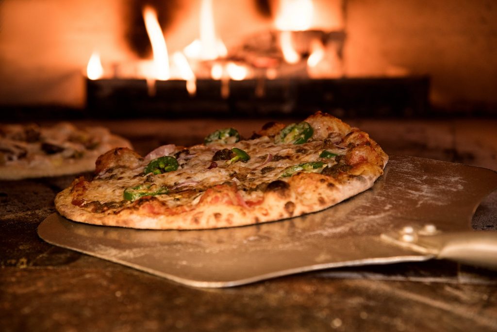 Pizza being cooked in a wood oven