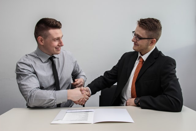 two men in suits shaking hands